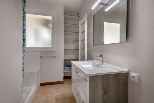 une salle de bain avec un lavabo et deux miroirs dans l'établissement Maison avec jardin pour 6 à St Brévin L’Océan, à Saint-Brévin-les-Pins