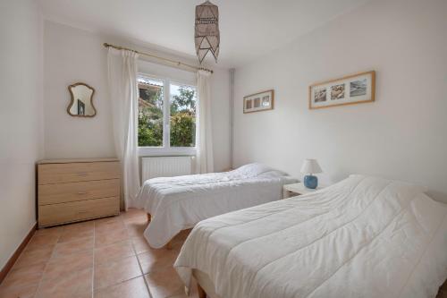 une chambre avec deux lits et une fenêtre dans l'établissement Maison avec jardin pour 6 à St Brévin L’Océan, à Saint-Brévin-les-Pins