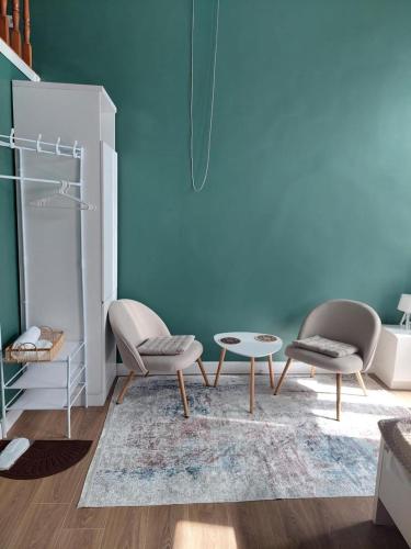 a living room with two chairs and a table at City Centre Apartment - Mari in Kutaisi