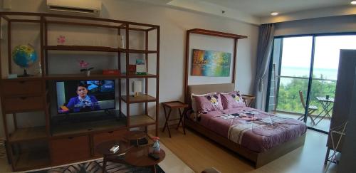 a bedroom with a bed and a tv in a room at Munchkin Seafront Residence bossku in Kuantan