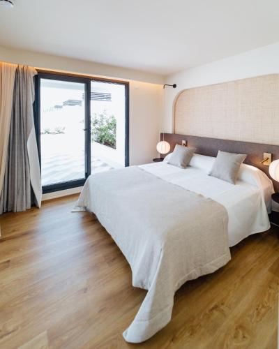 a bedroom with a large bed and a large window at Pacha Hotel in Ibiza Town