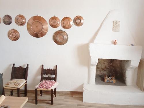 a living room with a fireplace and two chairs at Vasiliki Skyros Castle View in Skiros