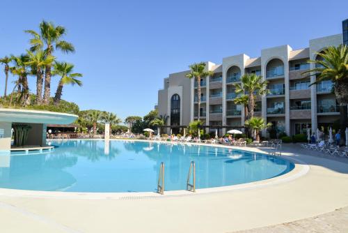 a large swimming pool in front of a hotel at Falésia Hotel - Adults Only in Albufeira