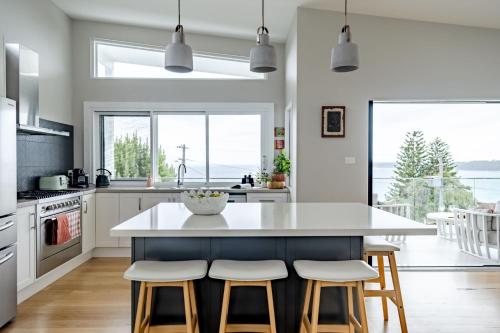 a kitchen with a large kitchen island with stools at Blue Horizon in Mollymook