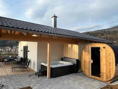een paviljoen met een hot tub op een patio bij Chalets Woid_Liebe&Glück in Bodenmais