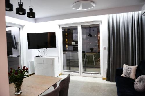 a living room with a table and a television at Apartament Królowej Jadwigi z garażem in Radom