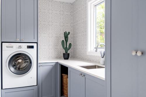a kitchen with a washing machine and a sink at Blue Horizon in Mollymook