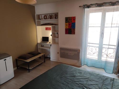 une chambre avec un lit, un bureau et une fenêtre dans l'établissement Petit Marais Niçois - Appartement 2P en étage élevé, à Nice