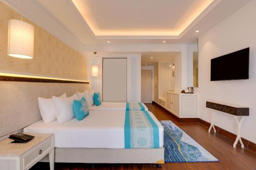 a hotel room with a bed and a television at Lemon Tree Premier Budhanilkantha Kathmandu, Nepal in Kathmandu
