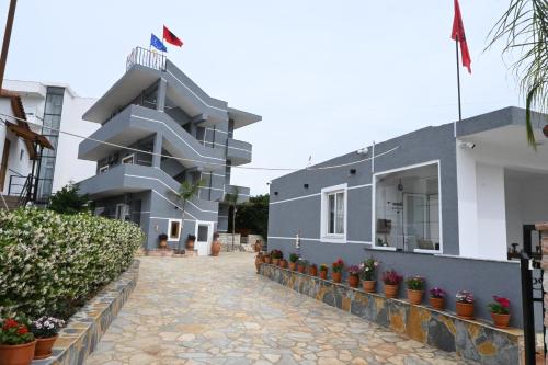 a building with potted plants in front of it at Vila La Familia in Ksamil