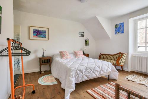 une chambre avec un lit blanc et une fenêtre dans l'établissement Belle demeure de pierre au calme à Erquy, à Erquy