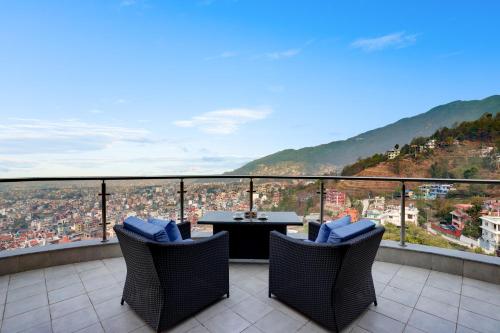 a balcony with a table and chairs with a view at Lemon Tree Premier Budhanilkantha Kathmandu, Nepal in Kathmandu