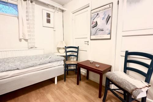 a bedroom with a bed and two chairs and a table at Superhomes 1 BR in Gothenburg