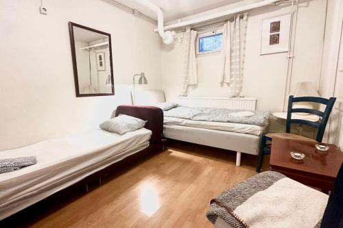 a room with two beds and a table and a mirror at Superhomes 1 BR in Gothenburg