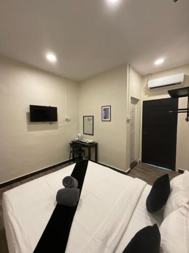 a bedroom with a bed and a flat screen tv at The Sky Inn in Kuantan