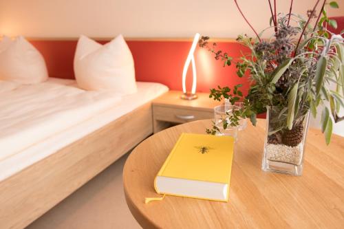 Zimmer mit einem Bett und einem Tisch mit einem Buch in der Unterkunft Pilgrims Inn Kreischa in Kreischa