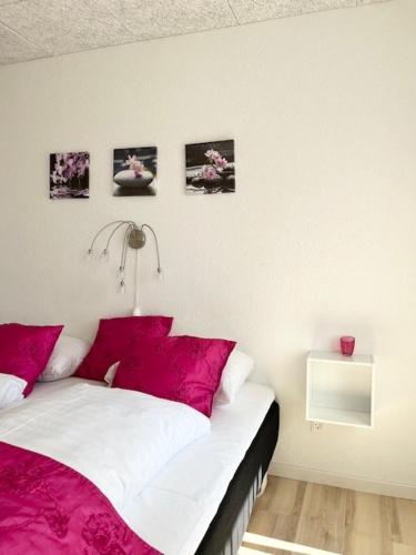 a bedroom with a bed with pink and white sheets at Biersted Kro in Åbybro