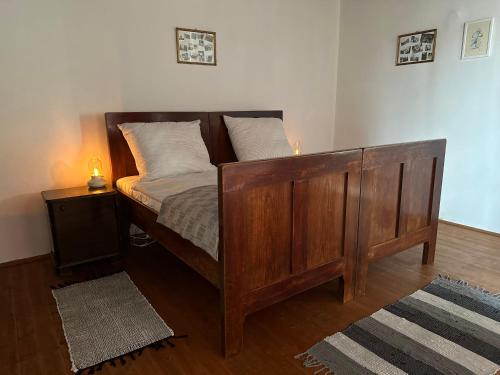 1 dormitorio con 1 cama de madera y 2 almohadas en Göcsej Kapuja Vendégház 