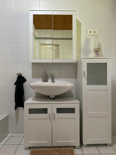 Baño blanco con lavabo y espejo en Göcsej Kapuja Vendégház 