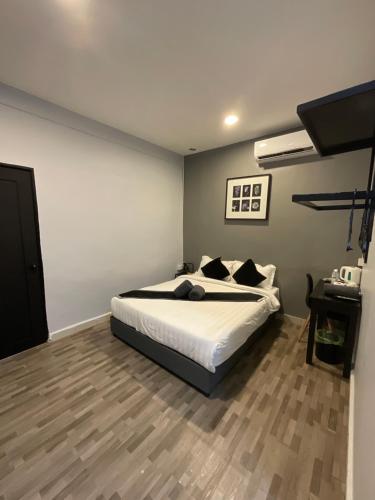 a bedroom with a bed and a desk in it at The Sky Inn in Kuantan