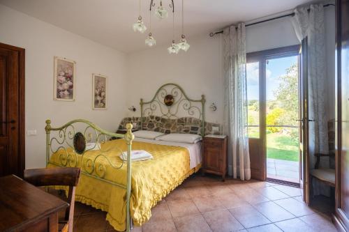 1 dormitorio con 1 cama con colcha amarilla en Agriturismo Podere Ristella - Wine&Food, en Montemassi