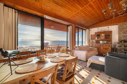 Sala de estar con mesa y vistas al océano en CALDERA close to the port, airport & Athens en Rafína