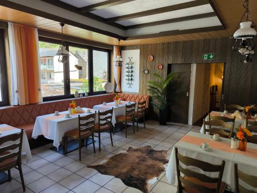a restaurant with tables and chairs in a room at HAUS BENICO -Pension- in Ernst