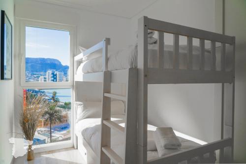 Dormitorio con litera y vistas al océano en Paradero de Ifach Sotavento CostaBlancaDreams, en Calpe