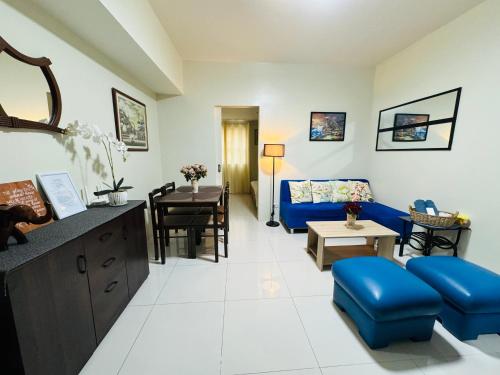 a living room with a blue couch and a table at PREMIUM CONDO AT BRENTHILL BAGUIO in Baguio