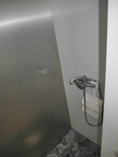 une cabine de douche avec une porte en métal avec un panier dans l'établissement La petite boulangère de pays, à Saint-Hilaire-de-Riez