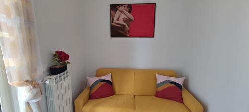 a yellow couch in a room with a picture on the wall at Casa vacanza Agrippina in Bacoli