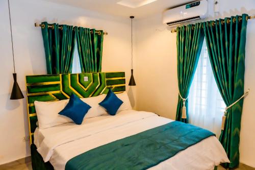 sypialnia z łóżkiem z zielonymi zasłonami w obiekcie El Elyon Hotel and Suites w mieście Lagos