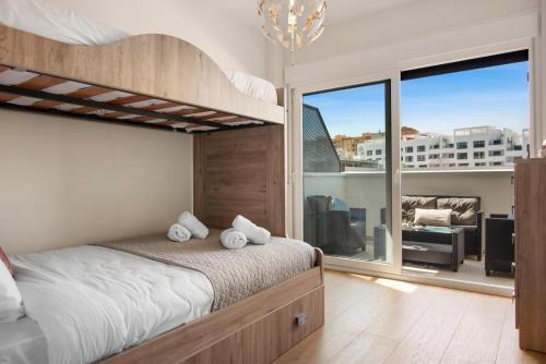 1 dormitorio con litera y ventana grande en Stunning flat with pool and padel in Wellingtonia M4, en Estepona