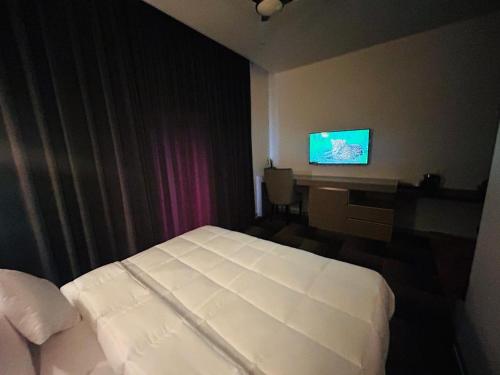 um quarto de hotel com uma cama, uma secretária e uma televisão em Eminence The Corbett em Jhirna