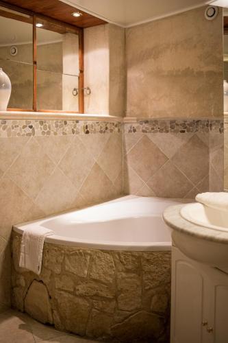 a bathroom with a bath tub and a sink at In Provence Hôtel - Expérience Authentique in Venelles