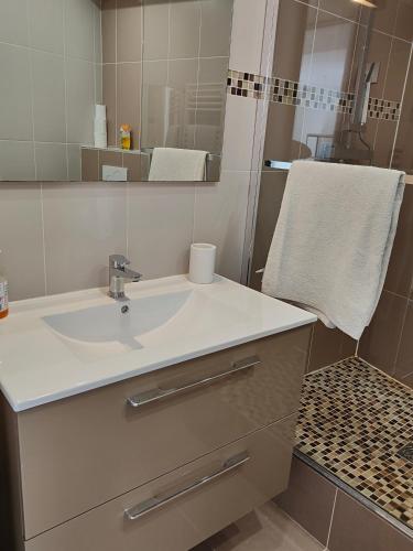 une salle de bain avec un lavabo blanc et un miroir dans l'établissement Petit Marais Niçois - Appartement 2P en étage élevé, à Nice
