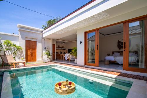 a villa with a swimming pool and a bedroom at Balibay 2 - Best Place by walking, Beach, Brand NEW Villa, Canggu in Kerobokan