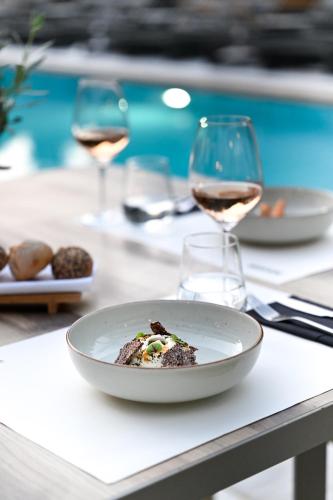 a plate of food on a table with wine glasses at La Piscine Art Hotel, Philian Hotels and Resorts in Skiathos Town