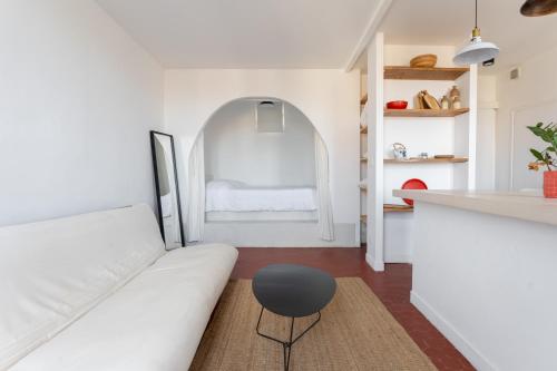 un salon avec un canapé blanc et une table dans l'établissement Paisible cocon au cœur du 7eme, à Marseille