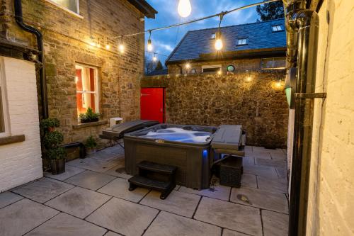 an outdoor patio with a hot tub in a courtyard at Hob Hurst in Buxton