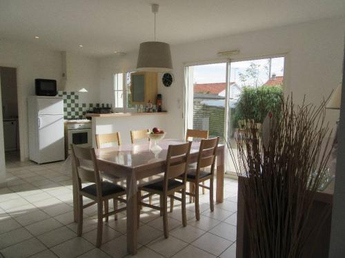 - une cuisine avec une table à manger et des chaises dans l'établissement La jardiniere des plages, à Saint-Hilaire-de-Riez