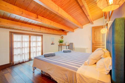 ein Schlafzimmer mit einem großen Bett und einer Holzdecke in der Unterkunft Casa con Piscina climatizada, Jacuzzi, Billar, Aire Acondicionado in Sant Lluís