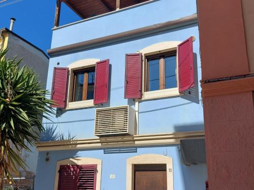 a white building with red shutters on its windows at Gondola Azzurra in Civitanova Marche