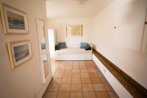 a living room with a white couch and a tiled floor at Al Beo in Finale Ligure