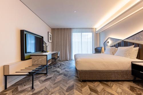a hotel room with a bed and a desk and a television at Coastlands Skye Hotel, Ridgeside, Umhlanga in Durban