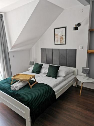 a bedroom with a bed with a table on it at Srokówka Resort in Dąbrówka