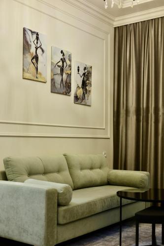 a living room with a couch and four paintings on the wall at Fiorella Gyumri in Gyumri