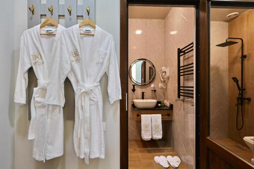 a bathroom with white robes hanging on a wall at Fiorella Gyumri in Gyumri