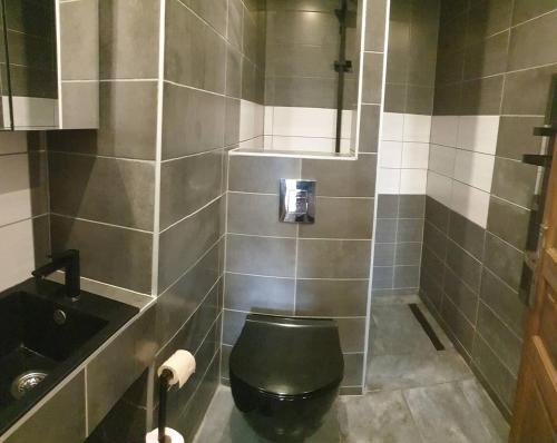 a bathroom with a black toilet and a sink at Chambre à la campagne in Mézières-sur-Couesnon