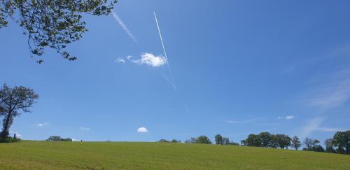 a kite flying in the sky over a green field at Chambre à la campagne in Mézières-sur-Couesnon